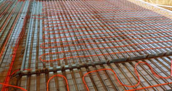 Modern manual laying of tuning water hydronic gas firing conduit supply on metal mesh insulation indoor new house room. Ground repair texture. Detail closeup macro view with space for text on grey net